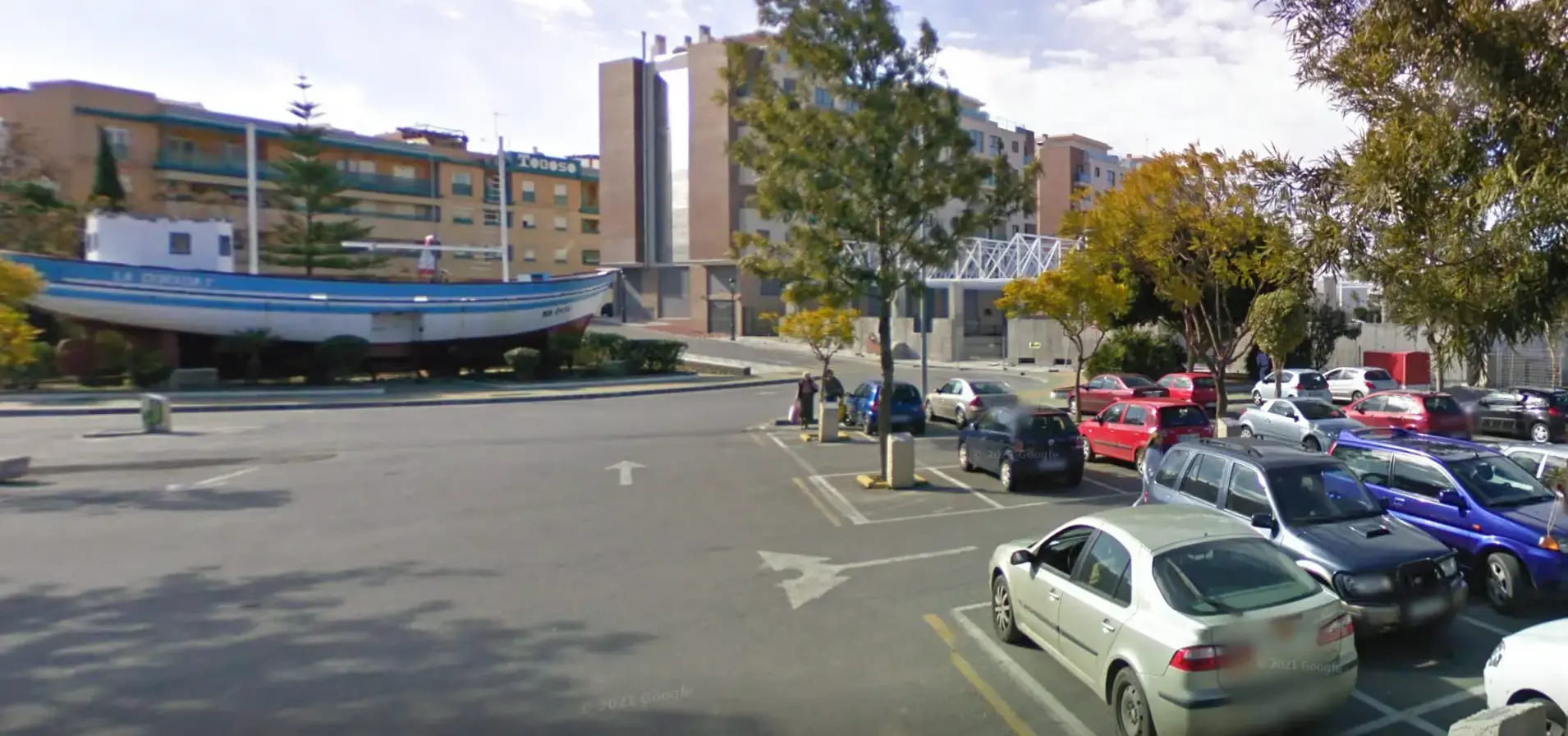 Plazas del parking junto al Barco de Chanquete en el parque Verano Azul, con edificios al fondo