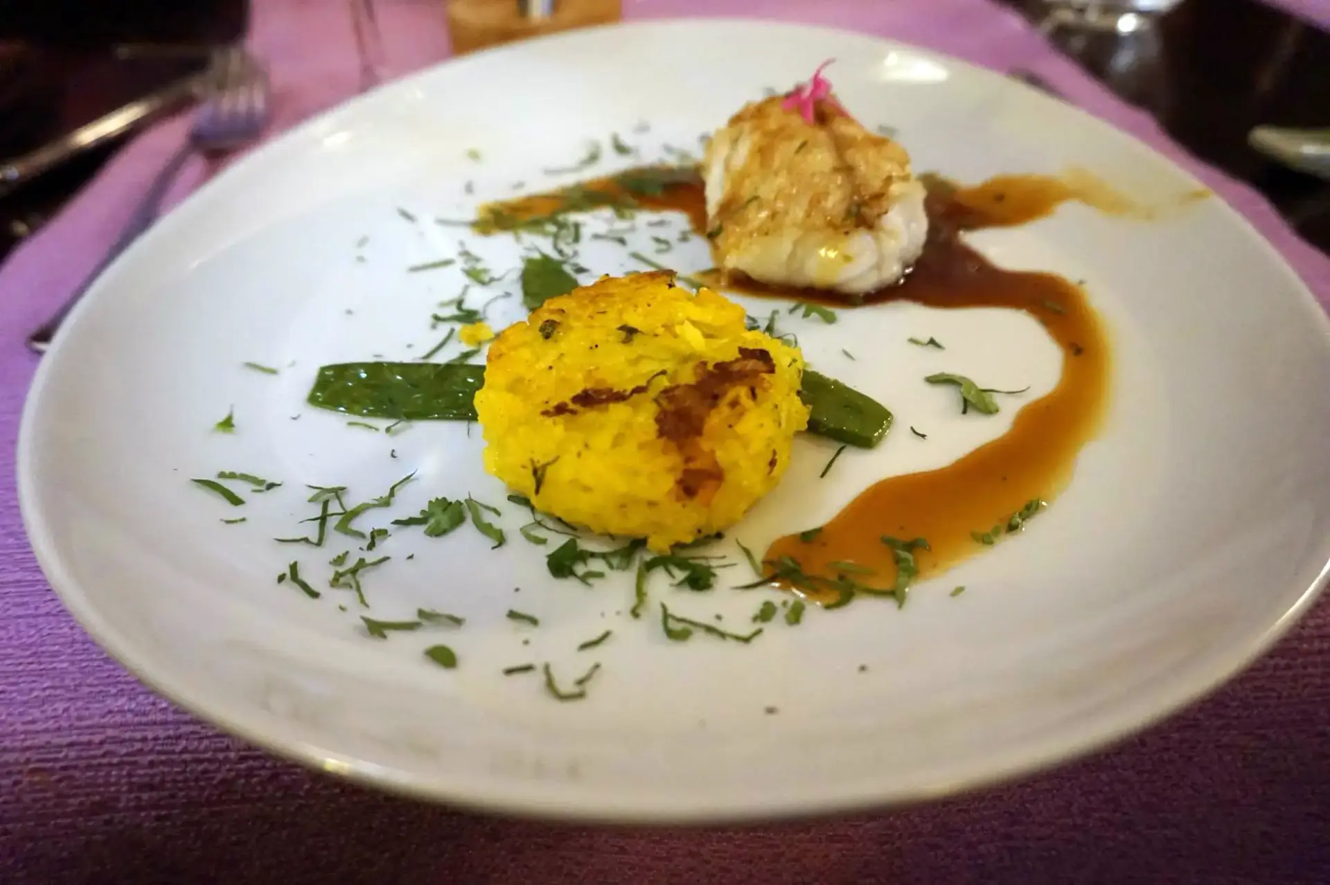 Golden rice with white fish, mangetout and sauce, served in a wide bowl