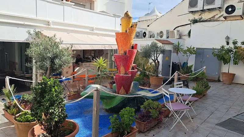 Shopping arcade courtyard with a mosaic fountain, potted plants and the café terrace