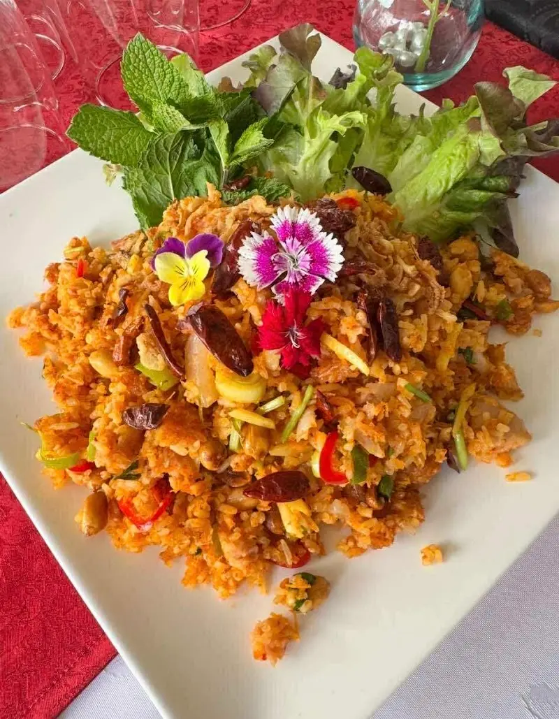 Spicy fried rice with dried chillies, mint, lettuce and edible flowers