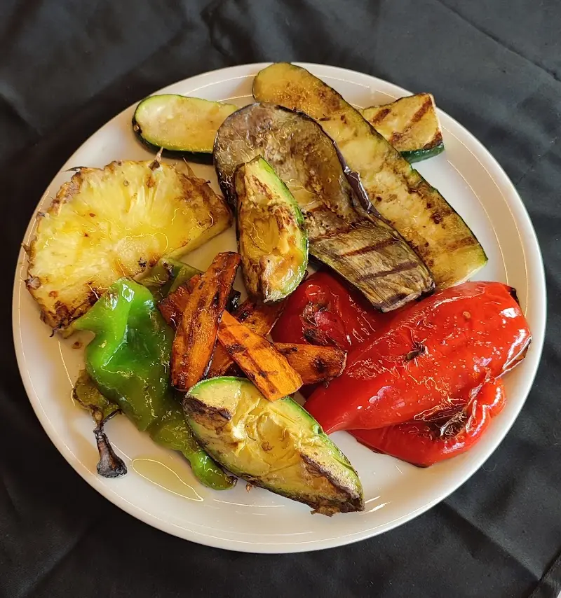 Plate of grilled vegetables with pineapple, courgette, aubergine, carrot and peppers