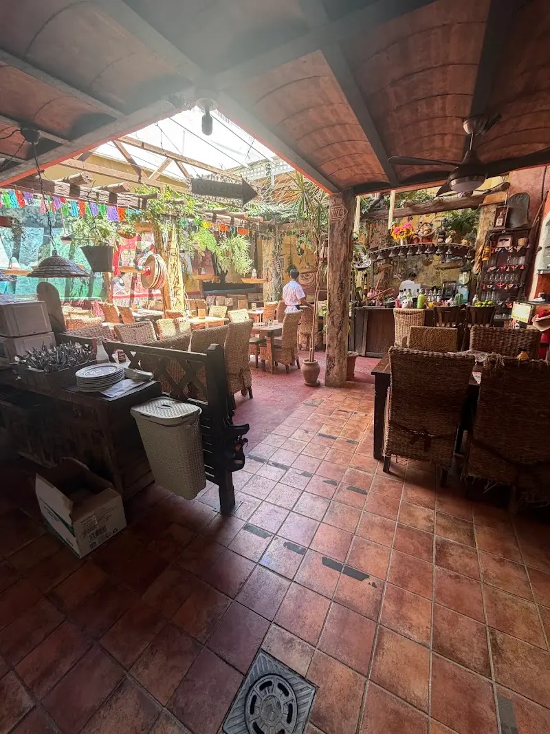 Inner courtyard with terracotta floor, wicker chairs, colourful bunting and a glass roof