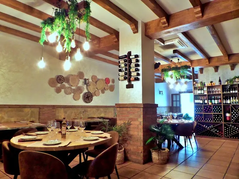 Dining room with round tables, a beamed ceiling, a wall wine rack and hanging plants