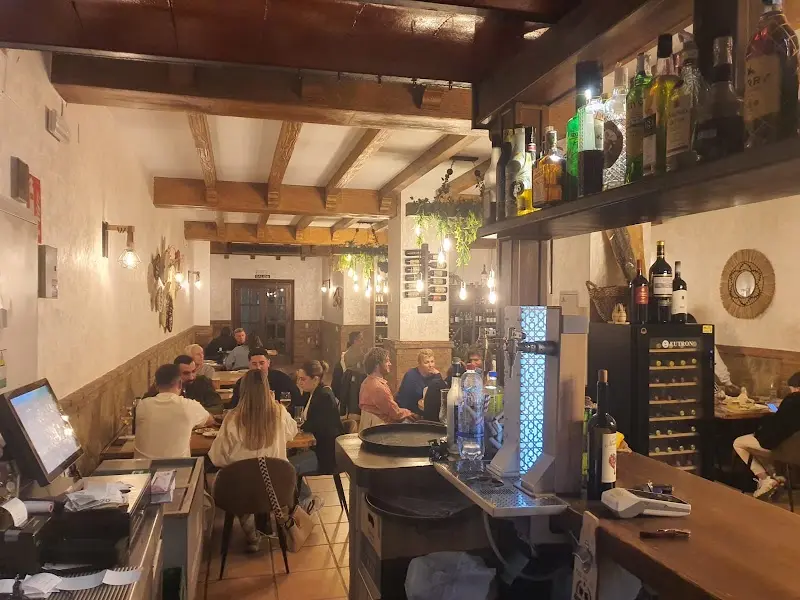 The bar and a dining room full of diners in the evening at Mogador Nerja