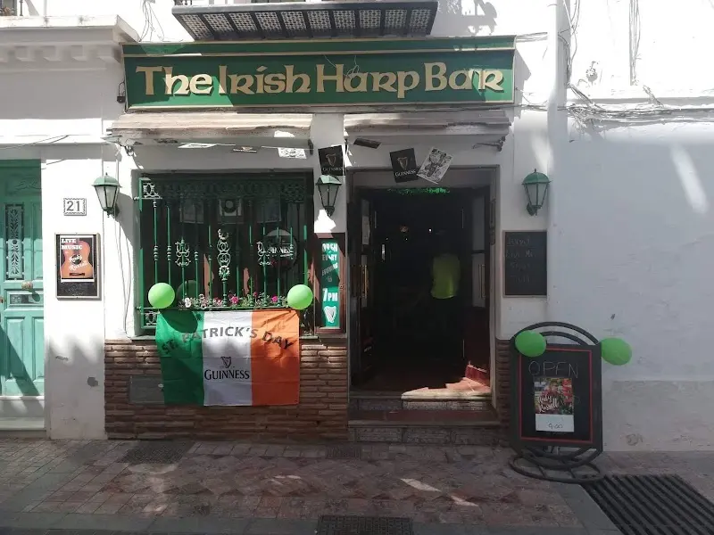 Front of The Irish Harp Bar decorated for St Patrick's Day with an Irish flag and green balloons