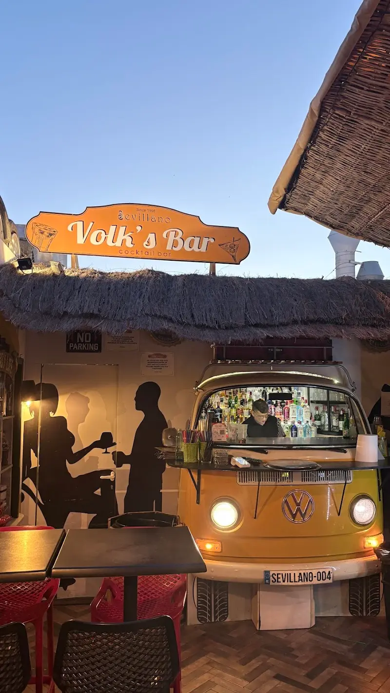 Cocktail bar inside a yellow Volkswagen camper van beneath the Volk's Bar sign