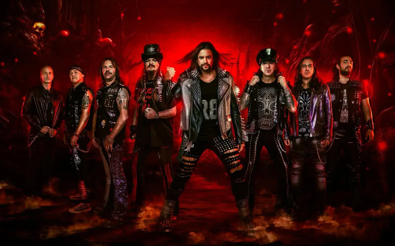 Grupo de rock con estética heavy posando ante un fondo rojo, imagen promocional de concierto