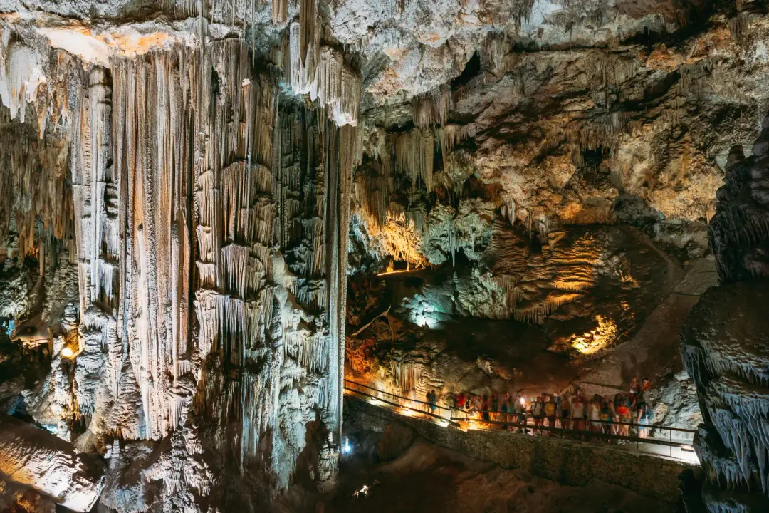 Columnas gigantes y pasarela iluminada dentro de la Cueva de Nerja